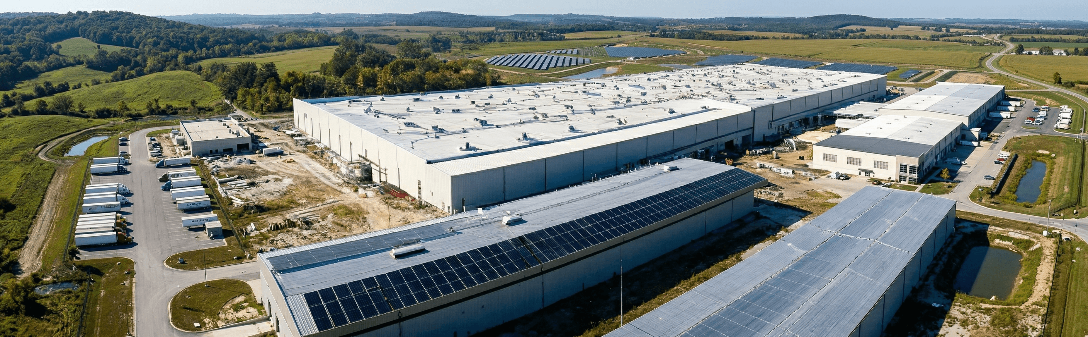 Cinematic wide shot of a large modern factory with rooftop solar panels